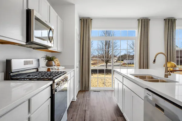 a kitchen with stainless steel appliances granite countertop a sink stove and cabinets