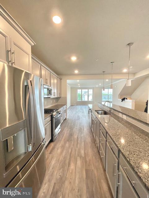 7103 Delegate Place Frederick, MD 21703 - Photo 9 of 42 a large kitchen with kitchen island a large counter top space a sink stainless steel appliances and cabinets