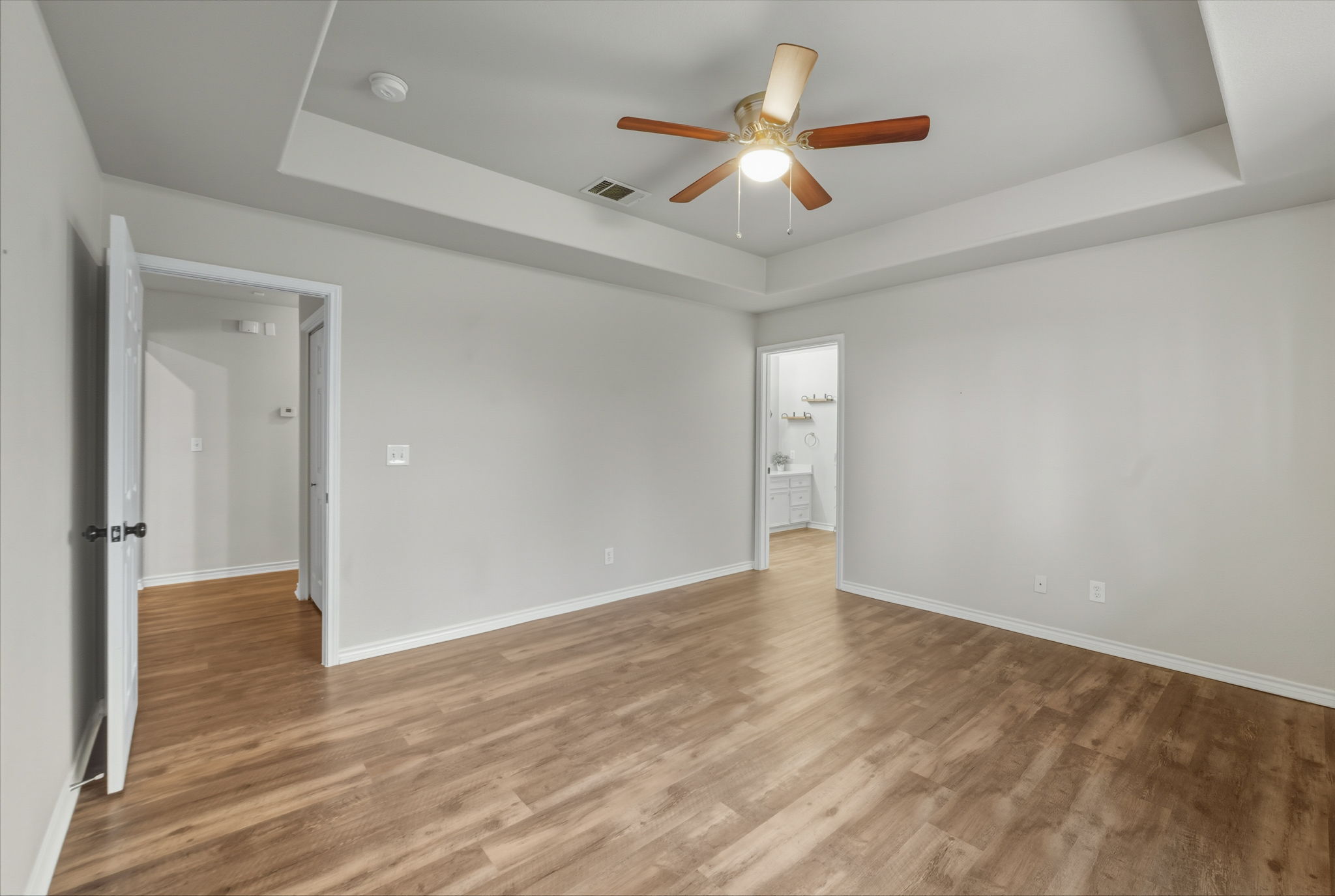 20808 Sandy Brown Lane Webberville, TX 78621 - Photo 13 of 40 an empty room with wooden floor and a ceiling fan