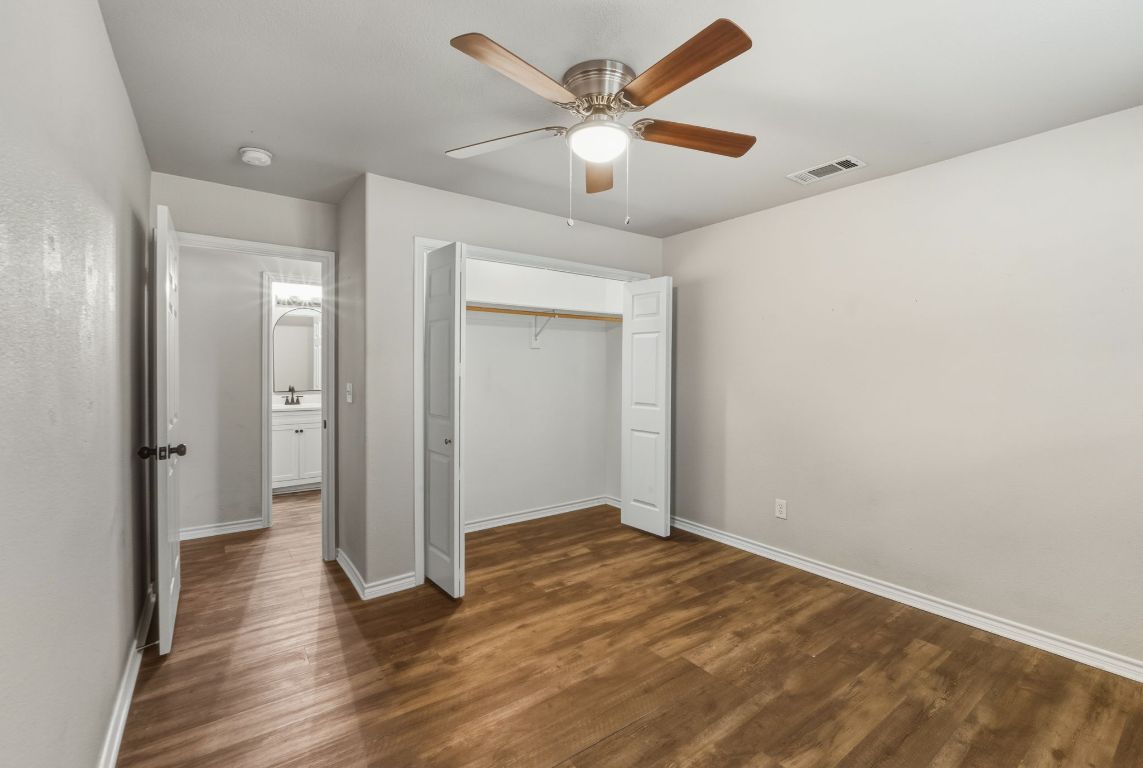 20808 Sandy Brown Lane Webberville, TX 78621 - Photo 24 of 40 an empty room with wooden floor and a ceiling fan