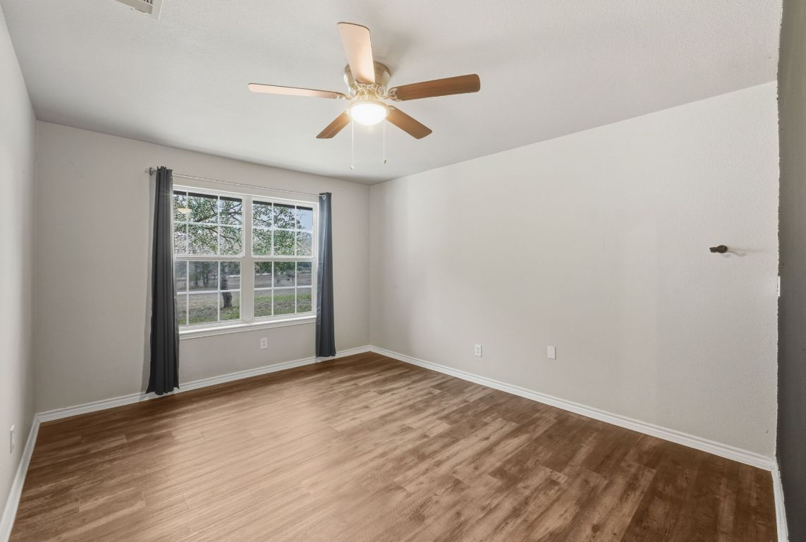 20808 Sandy Brown Lane Webberville, TX 78621 - Photo 26 of 40 a view of an empty room with wooden floor and a window