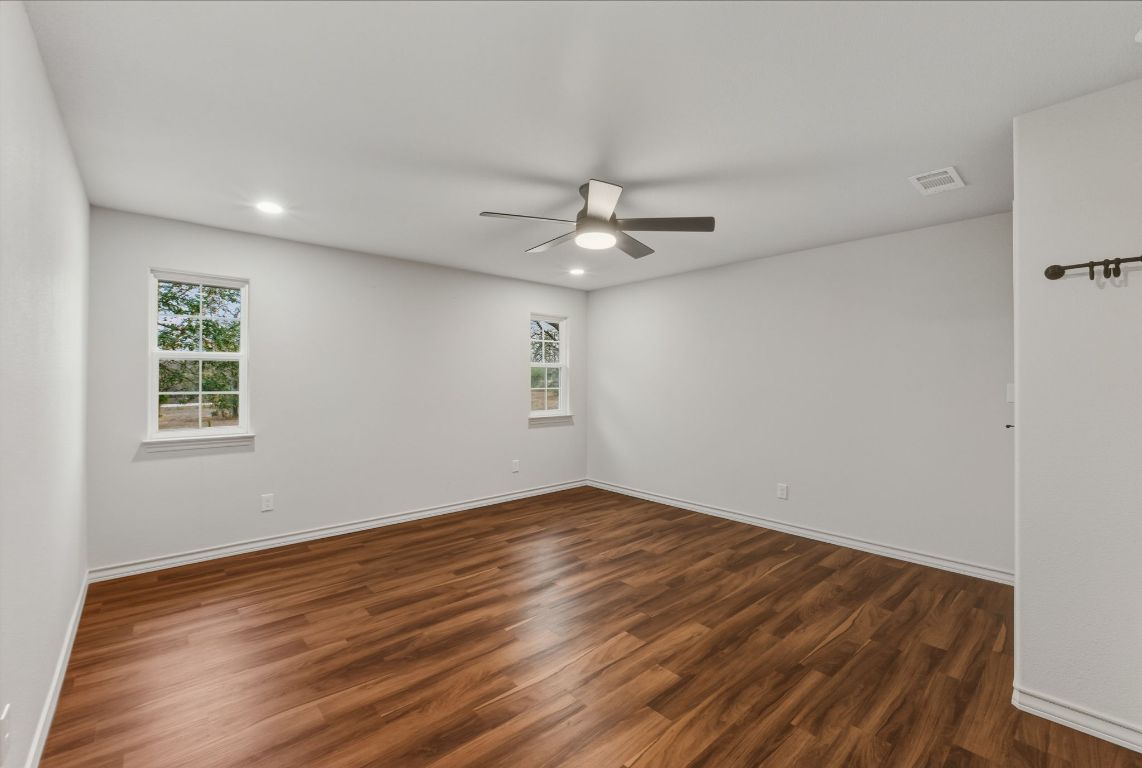 20808 Sandy Brown Lane Webberville, TX 78621 - Photo 30 of 40 a view of an empty room with a window and wooden floor