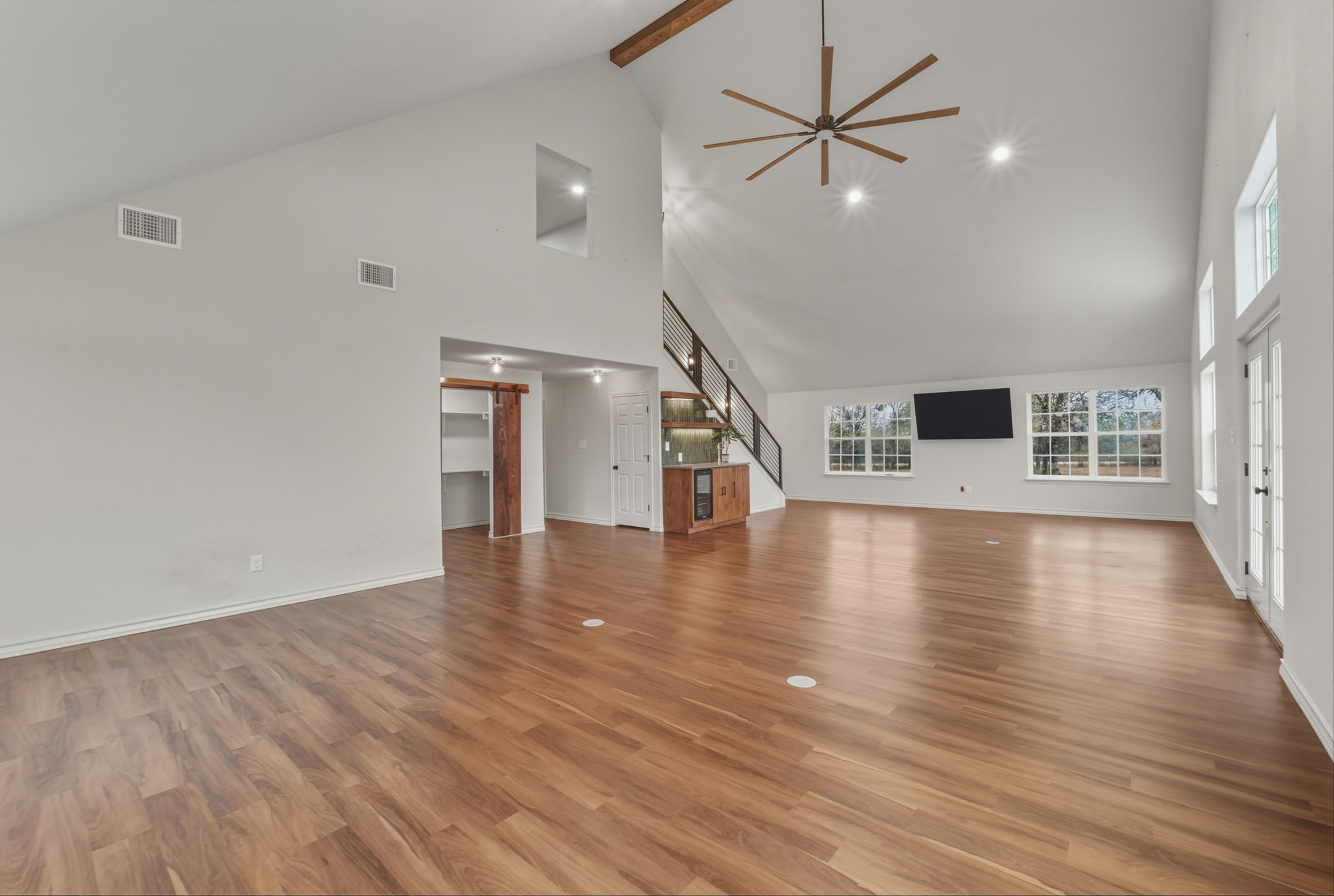 20808 Sandy Brown Lane Webberville, TX 78621 - Photo 3 of 40 a view of a livingroom with wooden floor a ceiling fan and windows