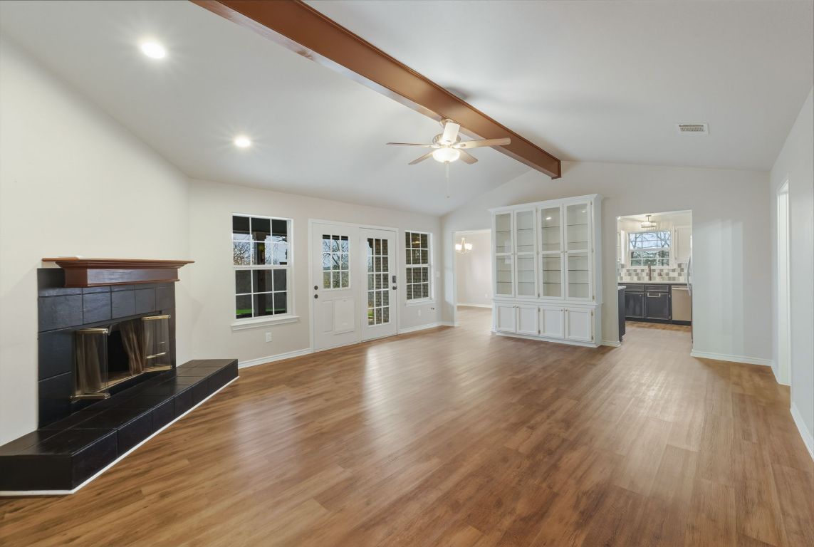 20808 Sandy Brown Lane Webberville, TX 78621 - Photo 4 of 40 a view of an empty room with wooden floor and a fireplace