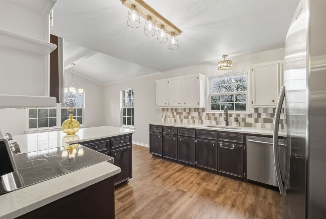 20808 Sandy Brown Lane Webberville, TX 78621 - Photo 7 of 40 a kitchen with stainless steel appliances granite countertop a sink dishwasher and a refrigerator with wooden floor