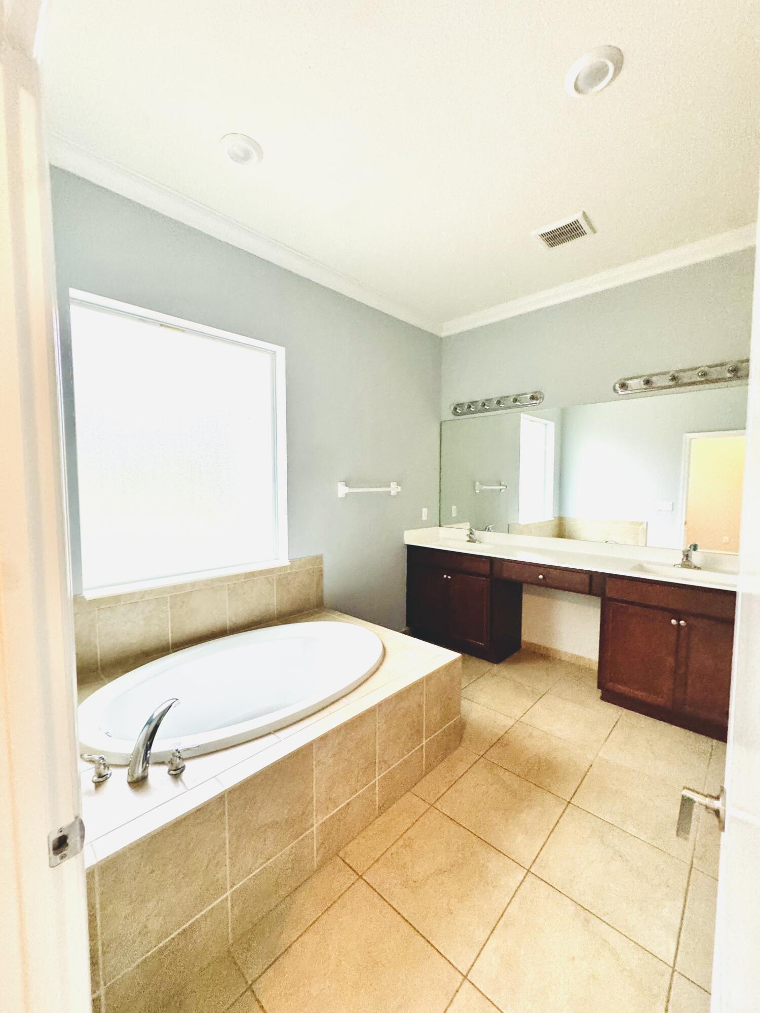 1807 Berkshire Circle Southwest Vero Beach, FL 32968 - Photo 14 of 22 a bathroom with a tub sink and mirror