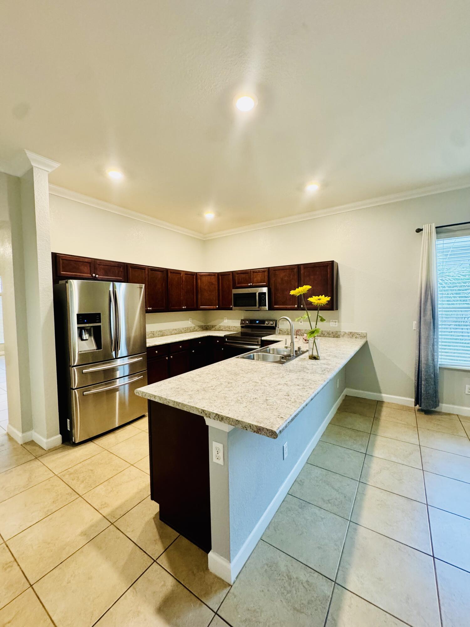 1807 Berkshire Circle Southwest Vero Beach, FL 32968 - Photo 18 of 22 a kitchen with stainless steel appliances kitchen island granite countertop a sink and cabinets
