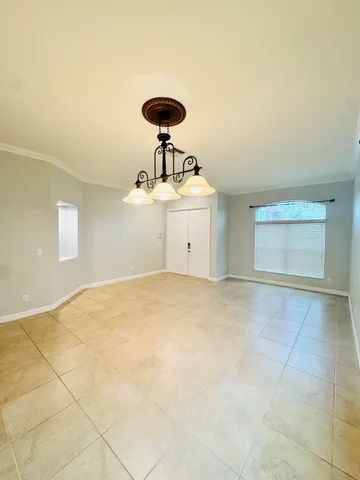 a view of a room with a ceiling fan and window