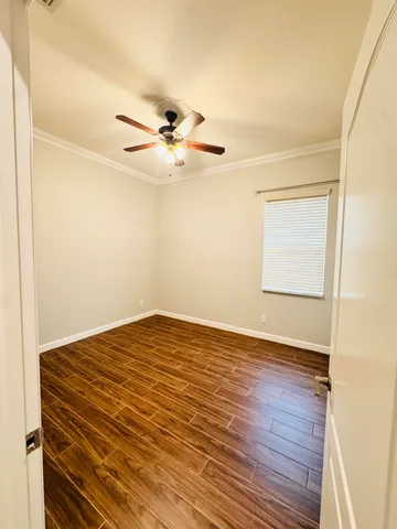 a view of a big room with wooden floor and a ceiling fan