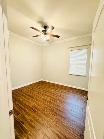 a view of a big room with wooden floor and ceiling fan