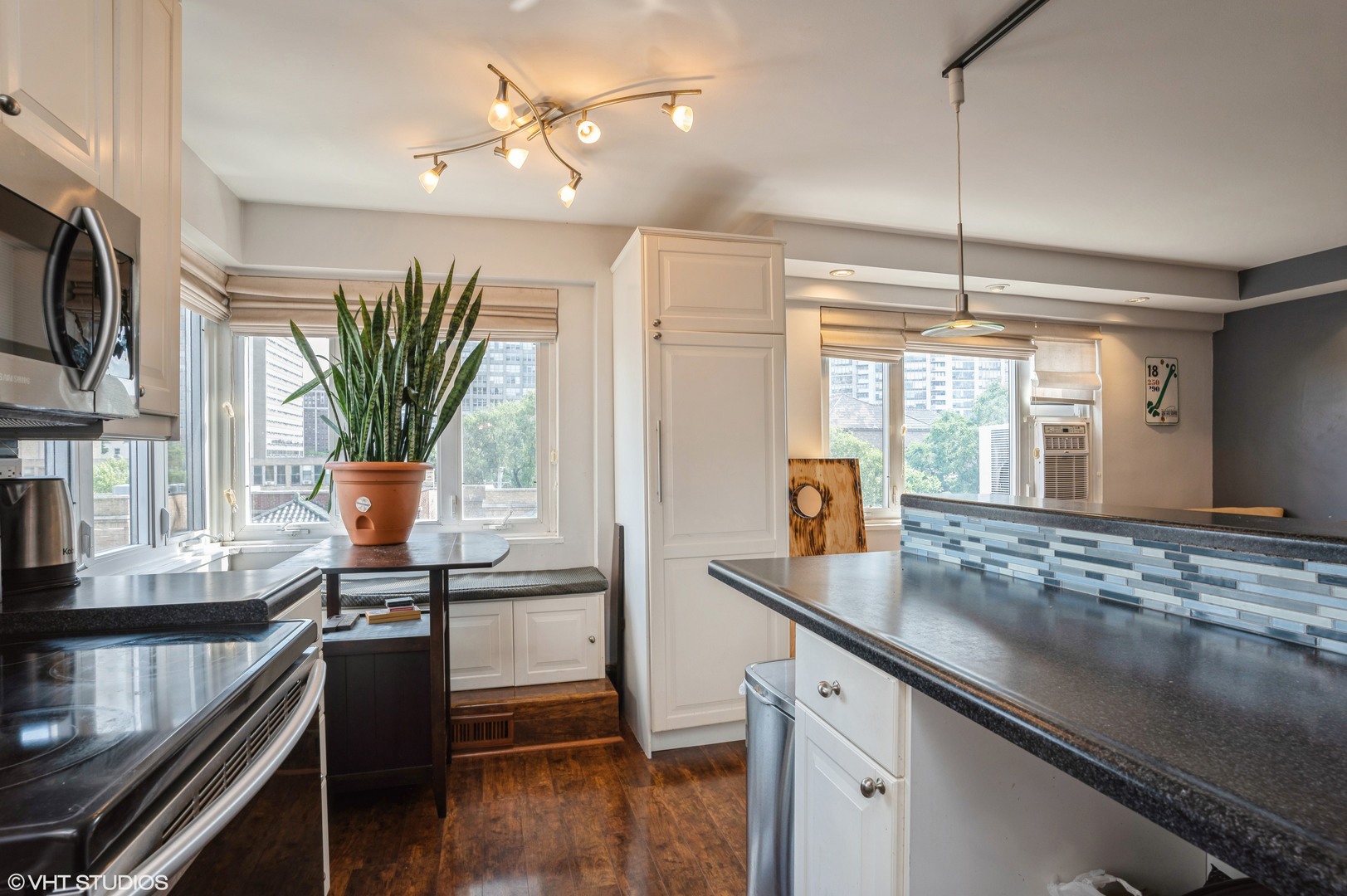700 West Bittersweet Place, Unit 506 Chicago, IL 60613 - Photo 7 of 11 a kitchen with stainless steel appliances granite countertop a sink a stove and a wooden floors