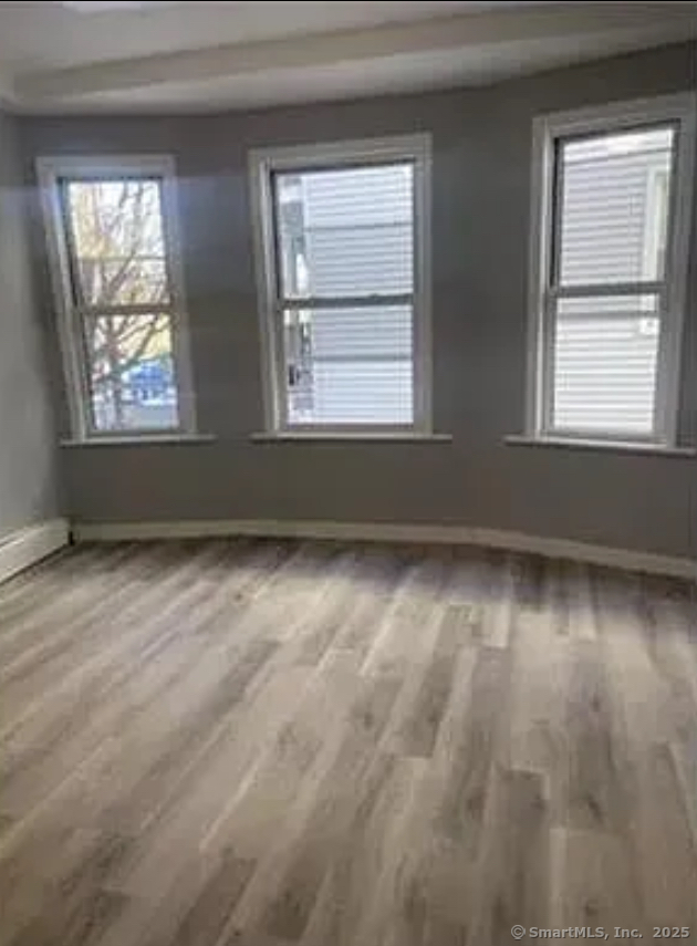 343 Pearl Street Bridgeport, CT 06608 - Photo 2 of 3 an empty room with wooden floor and windows