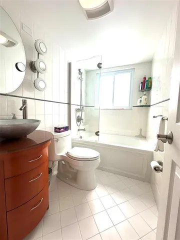a bathroom with a bathtub sink mirror vanity and toilet
