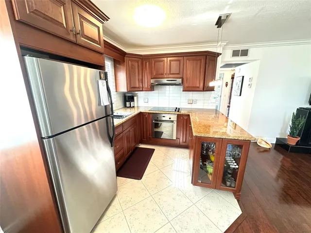 a kitchen with stainless steel appliances granite countertop a refrigerator a stove a sink dishwasher and a refrigerator