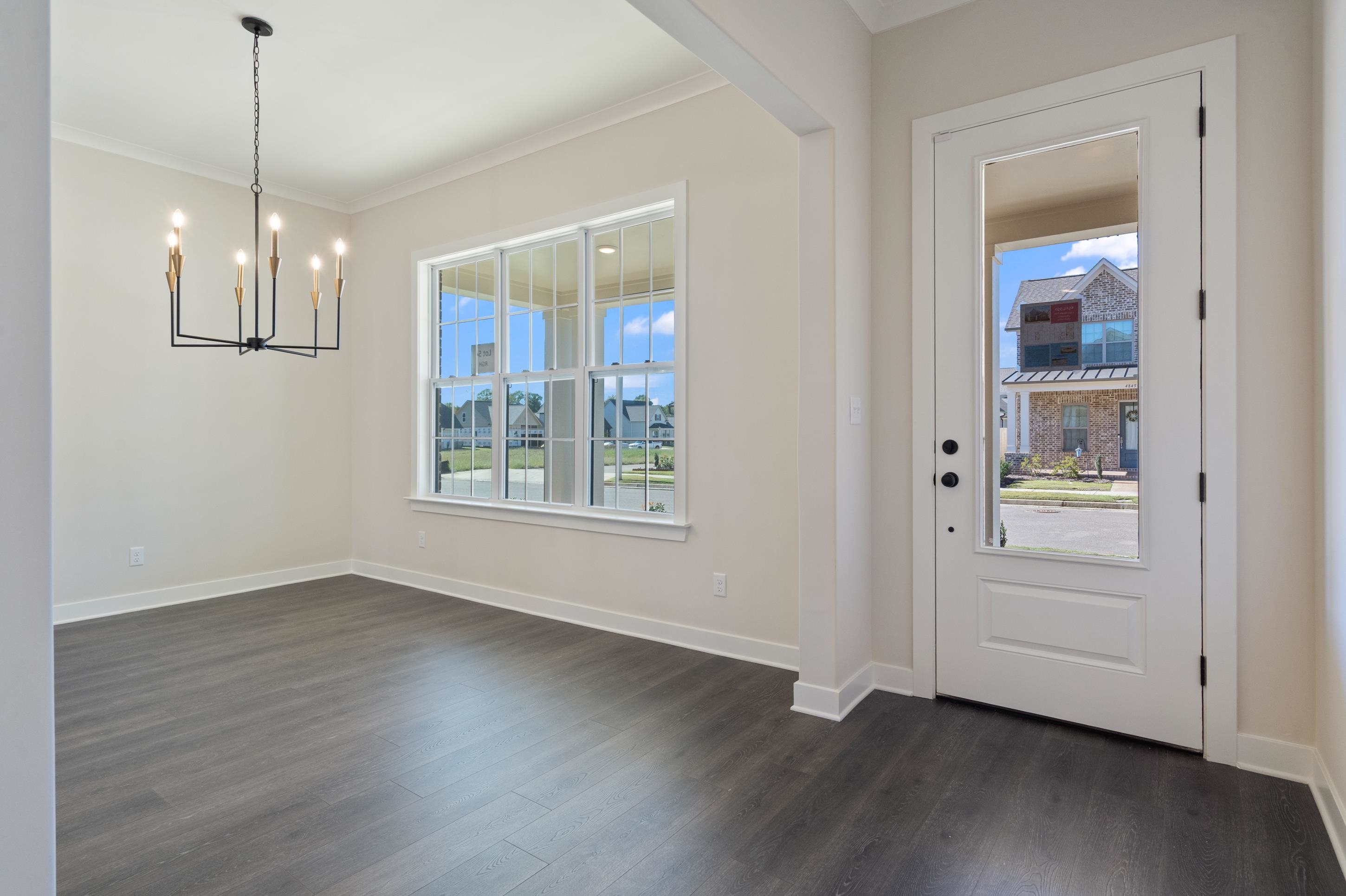 4844 Lyla Lane Collierville, TN 38017 - Photo 6 of 31 Unfurnished dining area featuring plenty of natural light, ornamental molding, dark wood-type flooring, and a chandelier