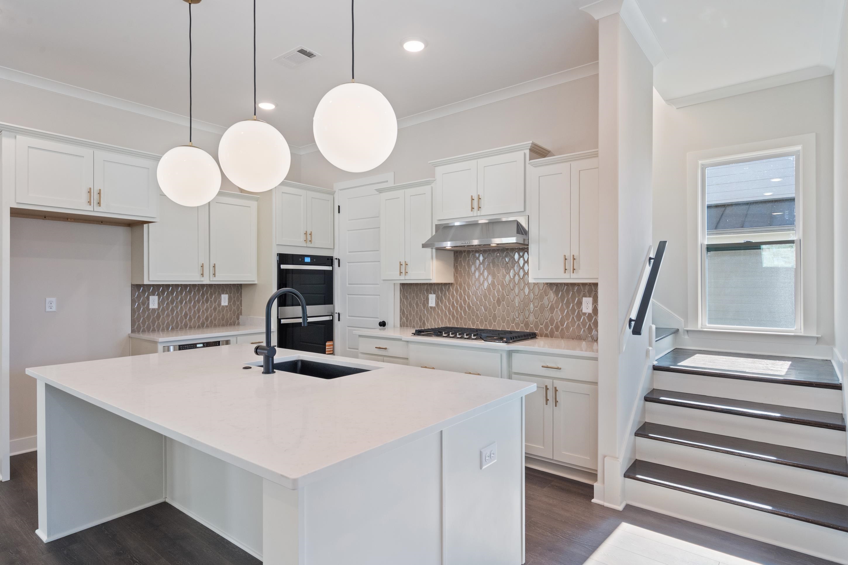 4844 Lyla Lane Collierville, TN 38017 - Photo 10 of 31 Kitchen featuring white cabinets, light quartz counters, a center island with sink, pendant lighting, and tasteful backsplash