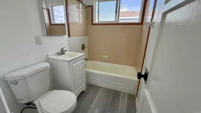 a white toilet sitting next to a bath tub
