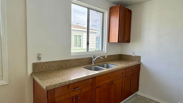 a kitchen with a granite countertop sink and a window