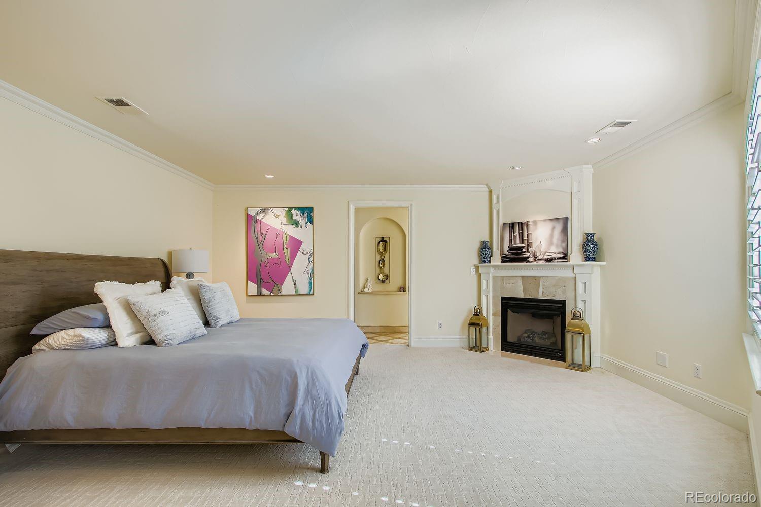 450 Detroit Street Denver, CO 80206 - Photo 13 of 28 a spacious bedroom with a bed and a fireplace