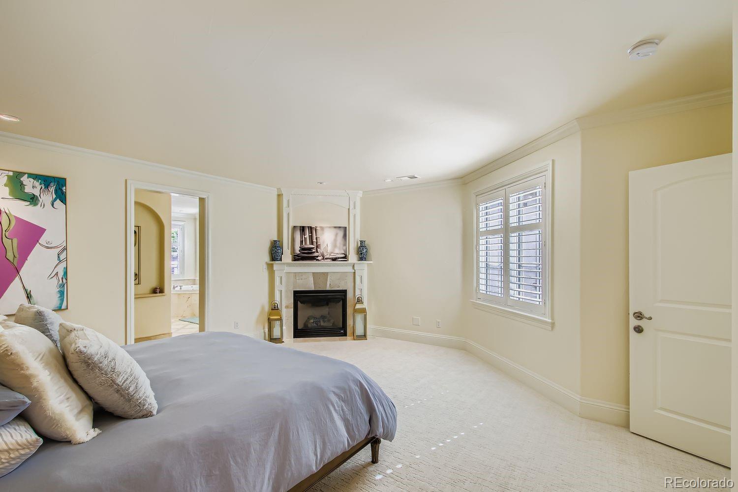 450 Detroit Street Denver, CO 80206 - Photo 14 of 28 a bedroom with a large bed a fireplace and a window