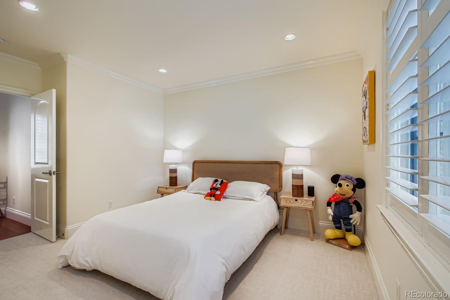 450 Detroit Street Denver, CO 80206 - Photo 18 of 28 a bed room with a bed and a chair