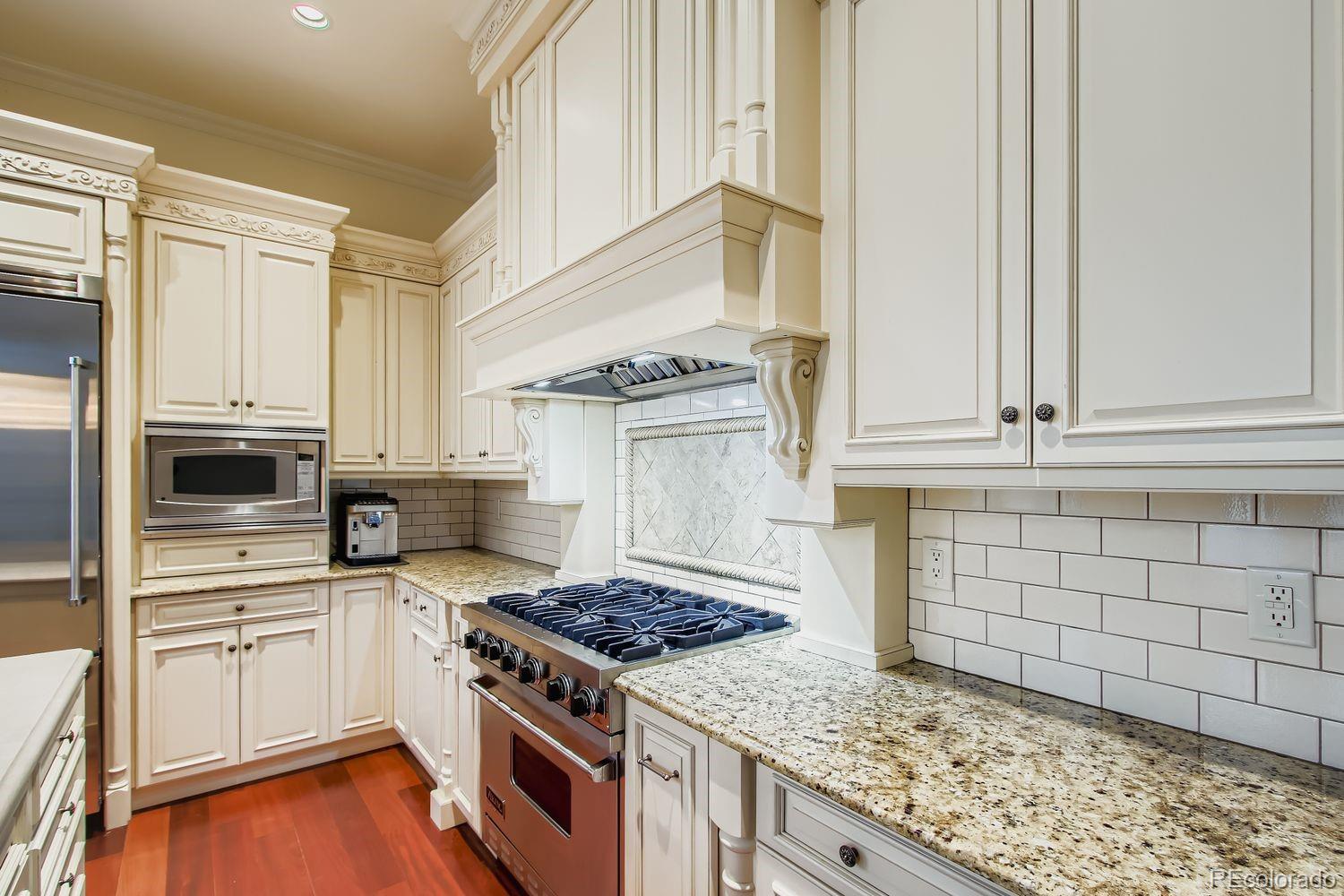 450 Detroit Street Denver, CO 80206 - Photo 7 of 28 a kitchen with stainless steel appliances granite countertop a stove a sink and a microwave