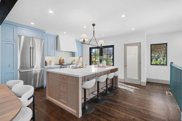 a kitchen with kitchen island white cabinets and stainless steel appliances