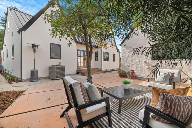 a view of a patio with couches table and chairs with wooden fence and floor