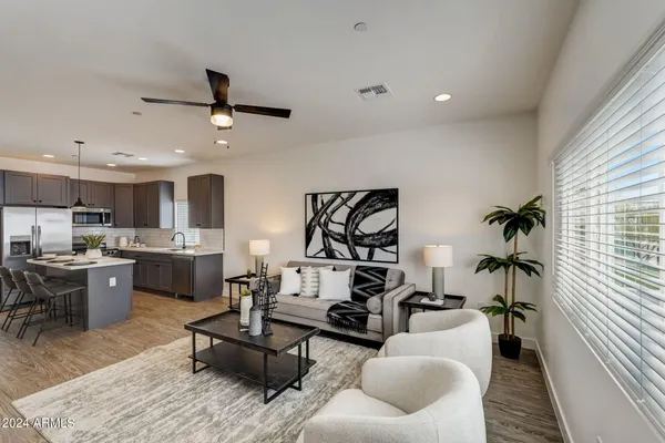 a living room with furniture kitchen view and a window