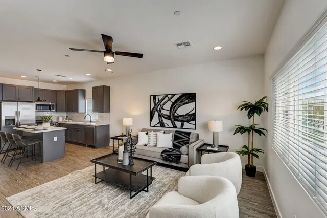 a living room with furniture kitchen view and a window