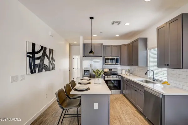 a kitchen with a sink a kitchen island and stainless steel appliances