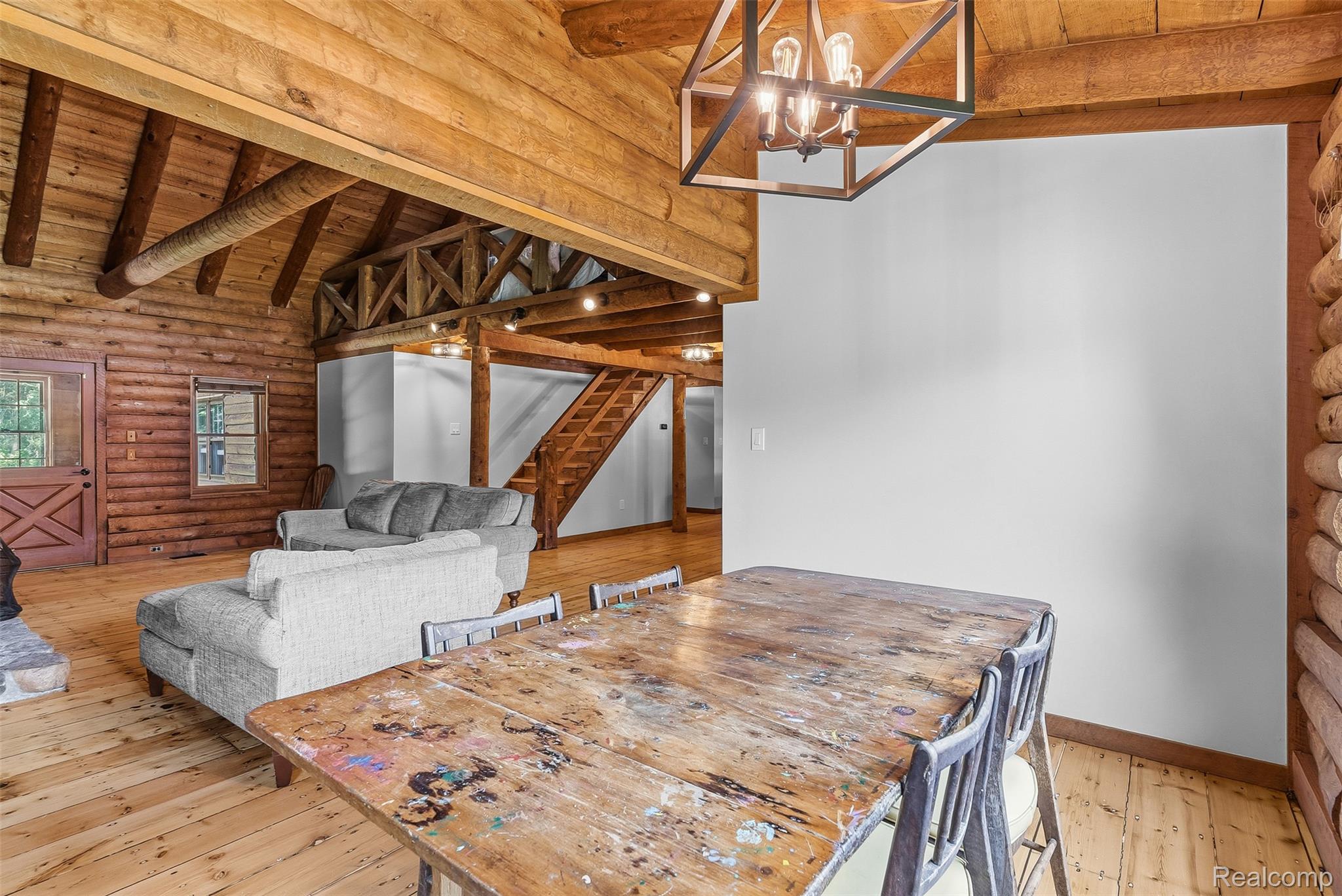 3656 Stanley Road Columbiaville, MI 48421 - Photo 11 of 65 Spacious interior featuring exposed log walls, vaulted wood ceilings with exposed beams, and light wood-finish flooring