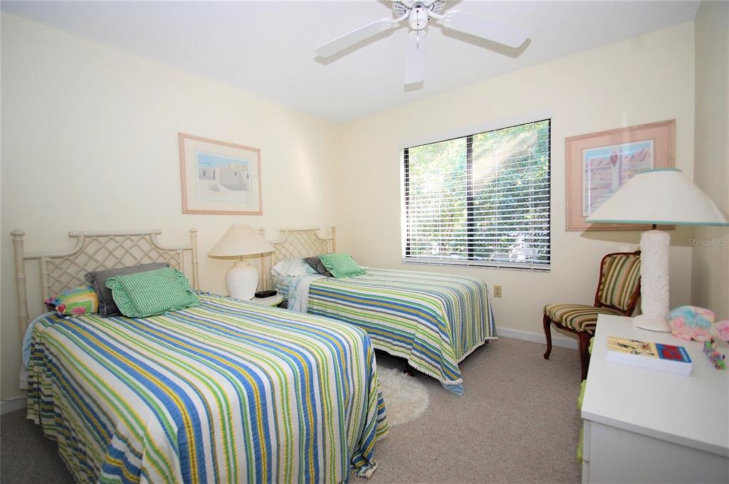 1526 Pelican Point Drive, Unit BA243 Sarasota, FL 34231 - Photo 10 of 24 a bedroom with two beds and a chandelier