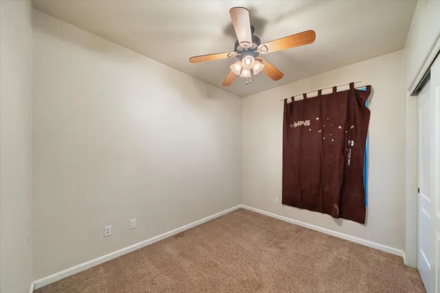 en empty room with a chandelier fan and a chandelier fan