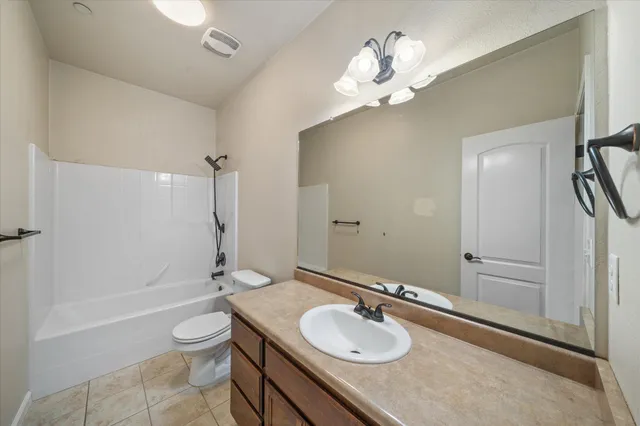 a bathroom with a granite countertop sink toilet a mirror and shower