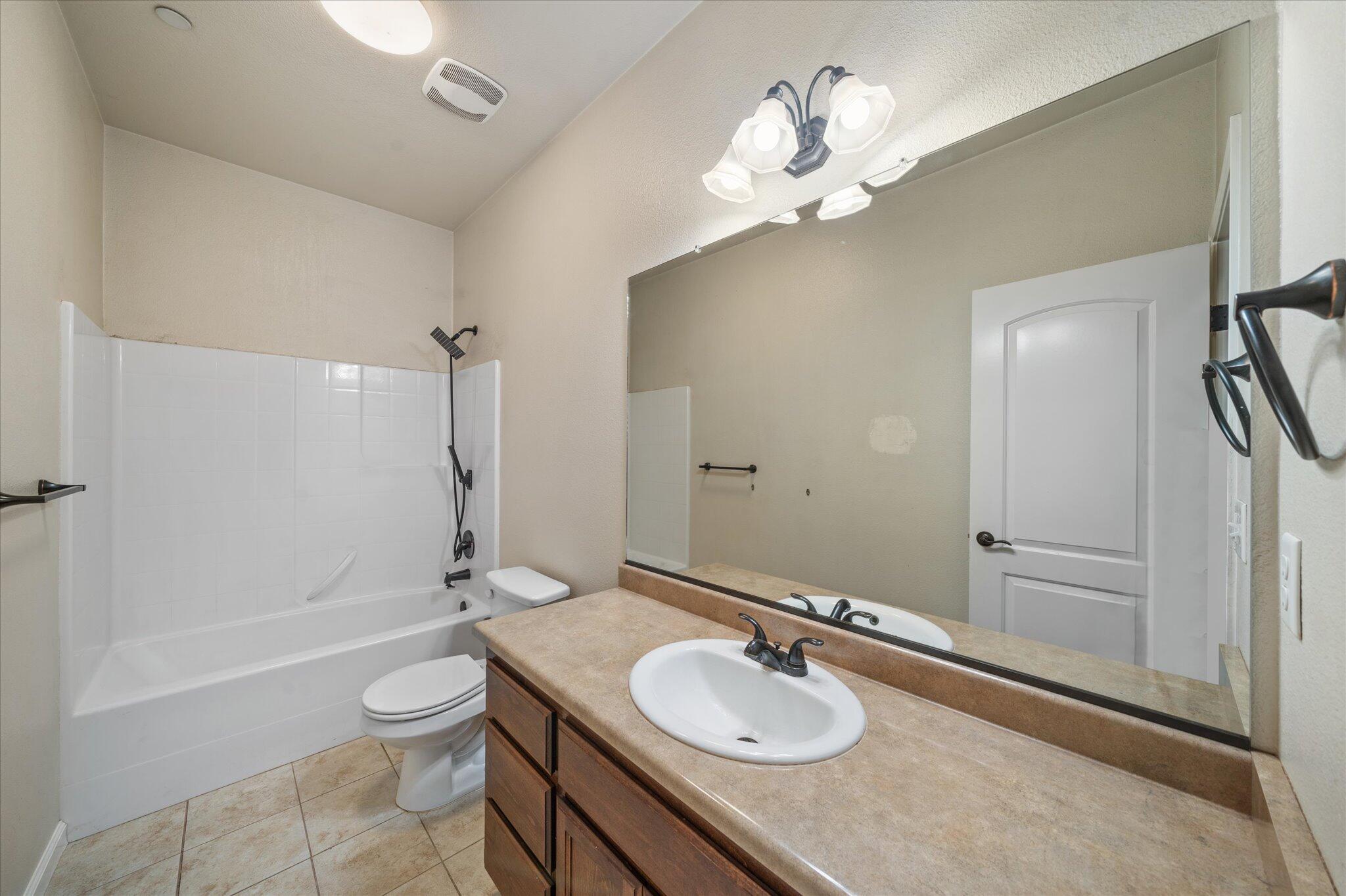 30821 Tinkerbell Lane Shingletown, CA 96088 - Photo 16 of 25 a bathroom with a granite countertop sink toilet a mirror and shower