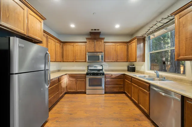 a kitchen with granite countertop stainless steel appliances and window