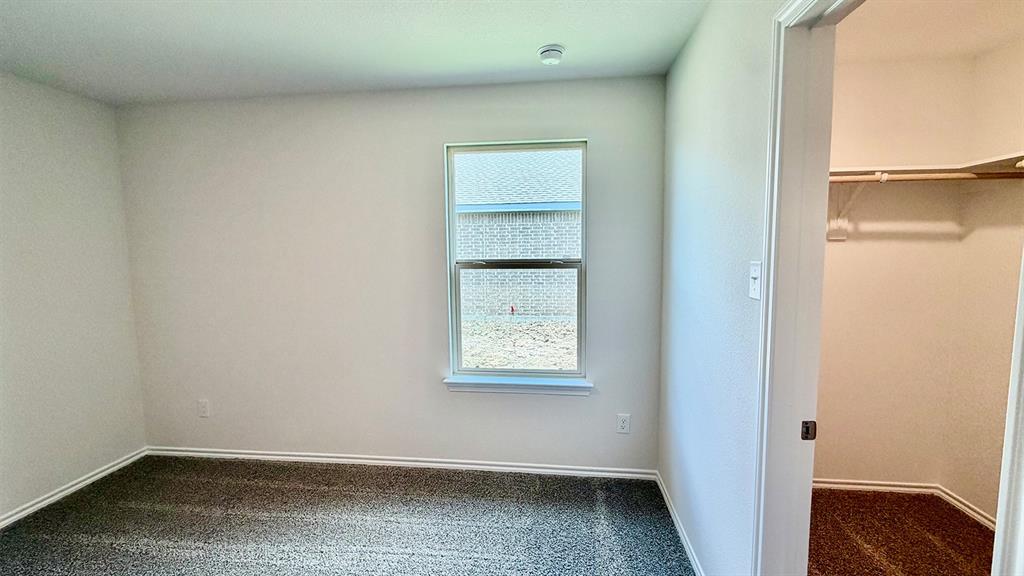 2003 Reveille Way Terrell, TX 75160 - Photo 19 of 25 Room featuring neutral wall finishes, carpet flooring, a single window, and a built-in closet with shelving