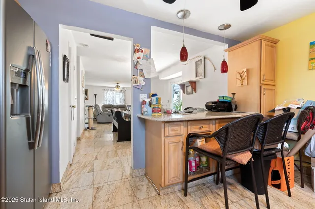 a kitchen with stainless steel appliances kitchen island granite countertop a refrigerator and microwave