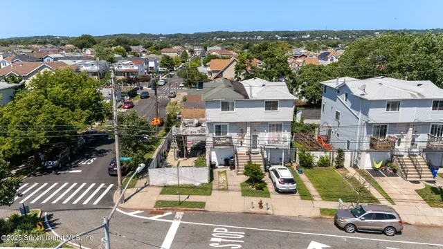 an aerial view of multiple houses with a yard