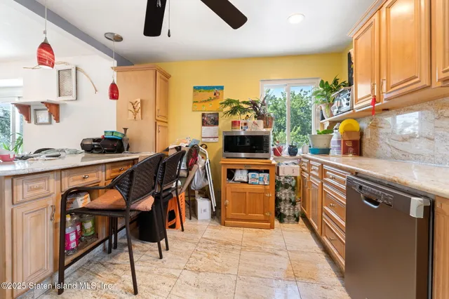 a kitchen with stainless steel appliances kitchen island granite countertop a stove top oven a sink a dining table and chairs with wooden floor