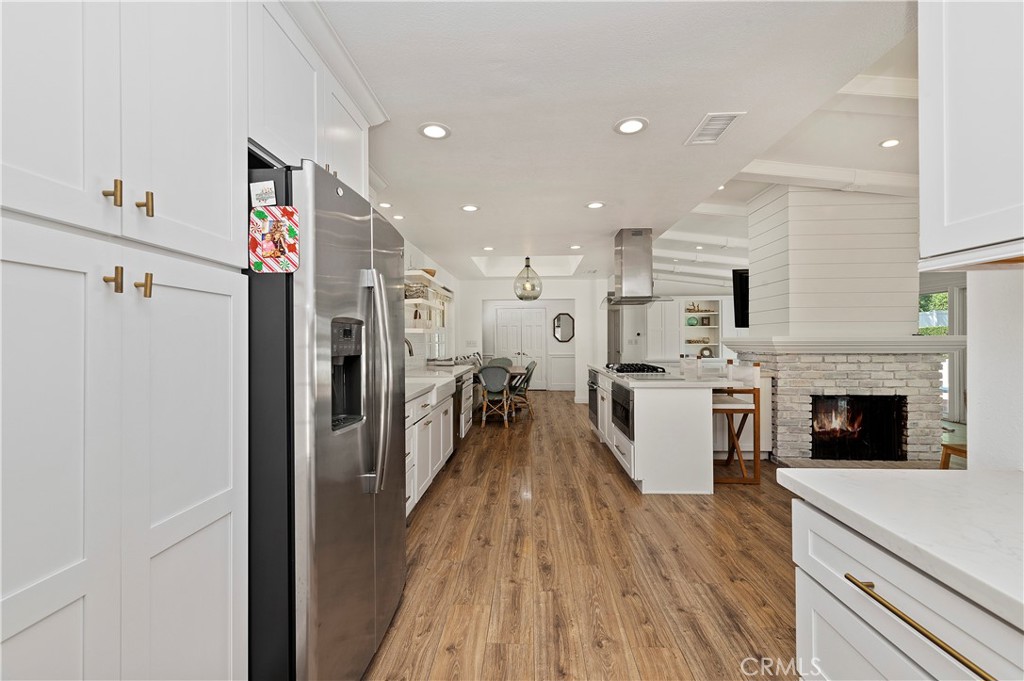 7398 Whitegate Avenue Riverside, CA 92506 - Photo 15 of 51 a living room with stainless steel appliances furniture a fireplace and a kitchen view
