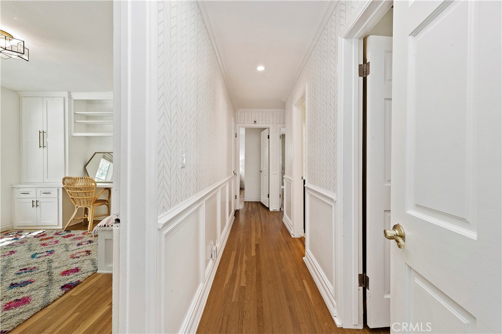 7398 Whitegate Avenue Riverside, CA 92506 - Photo 24 of 51 a view of a hallway with wooden floor and furniture
