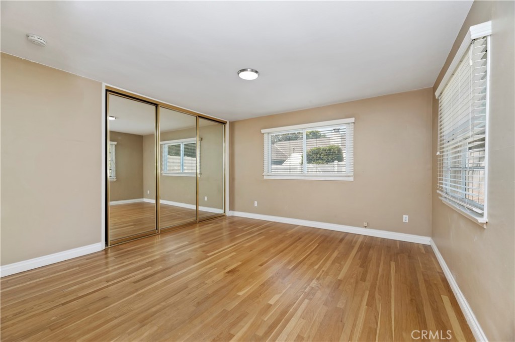 7398 Whitegate Avenue Riverside, CA 92506 - Photo 30 of 51 an empty room with wooden floor and windows