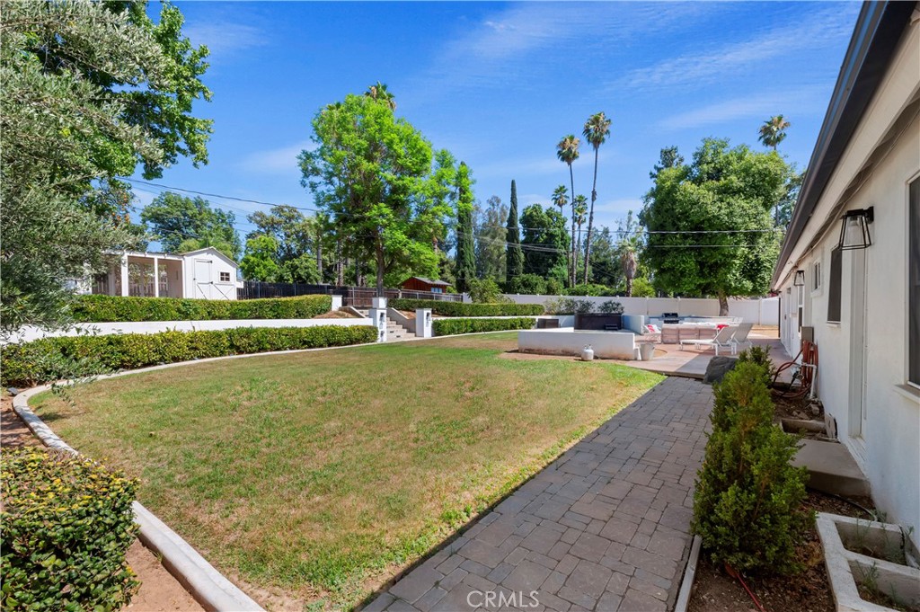 7398 Whitegate Avenue Riverside, CA 92506 - Photo 39 of 51 a view of a swimming pool with a bench and trees around