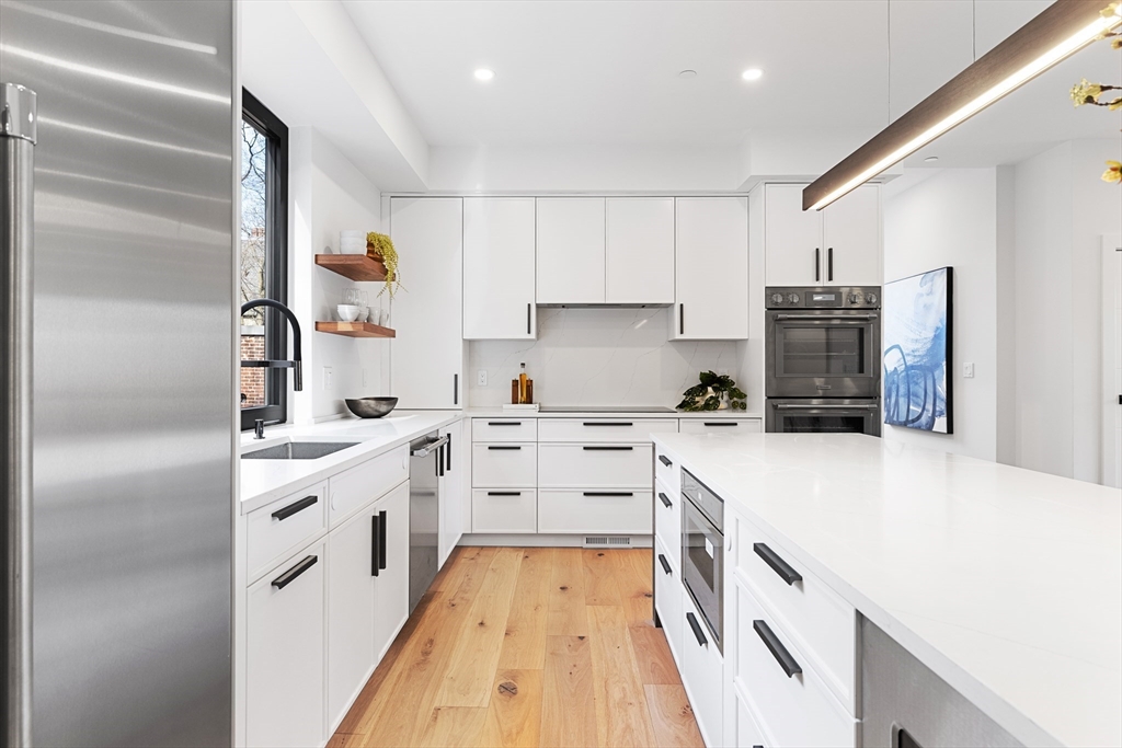 41 University Road, Unit 2 Brookline, MA 02445 - Photo 10 of 33 a kitchen with white cabinets and appliances