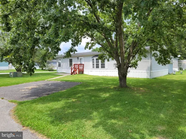 a front view of a house with a yard and trees