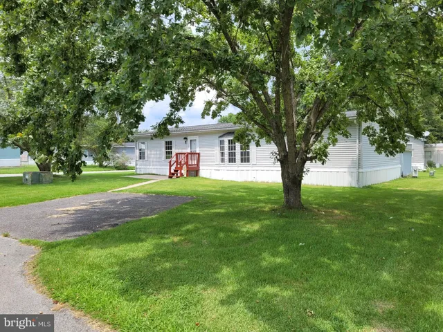 a front view of a house with a yard and trees