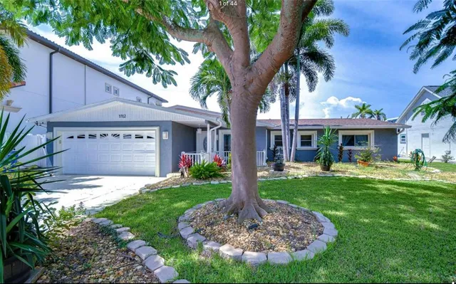 a front view of a house with a yard garage and outdoor seating