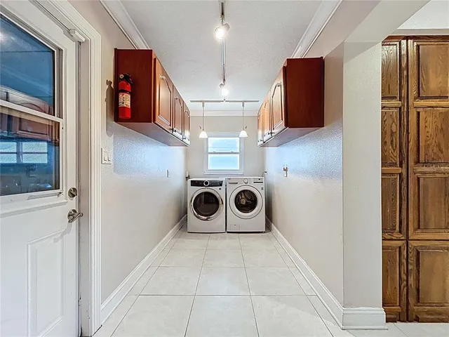 an aerial view of a house with swimming pool and large trees